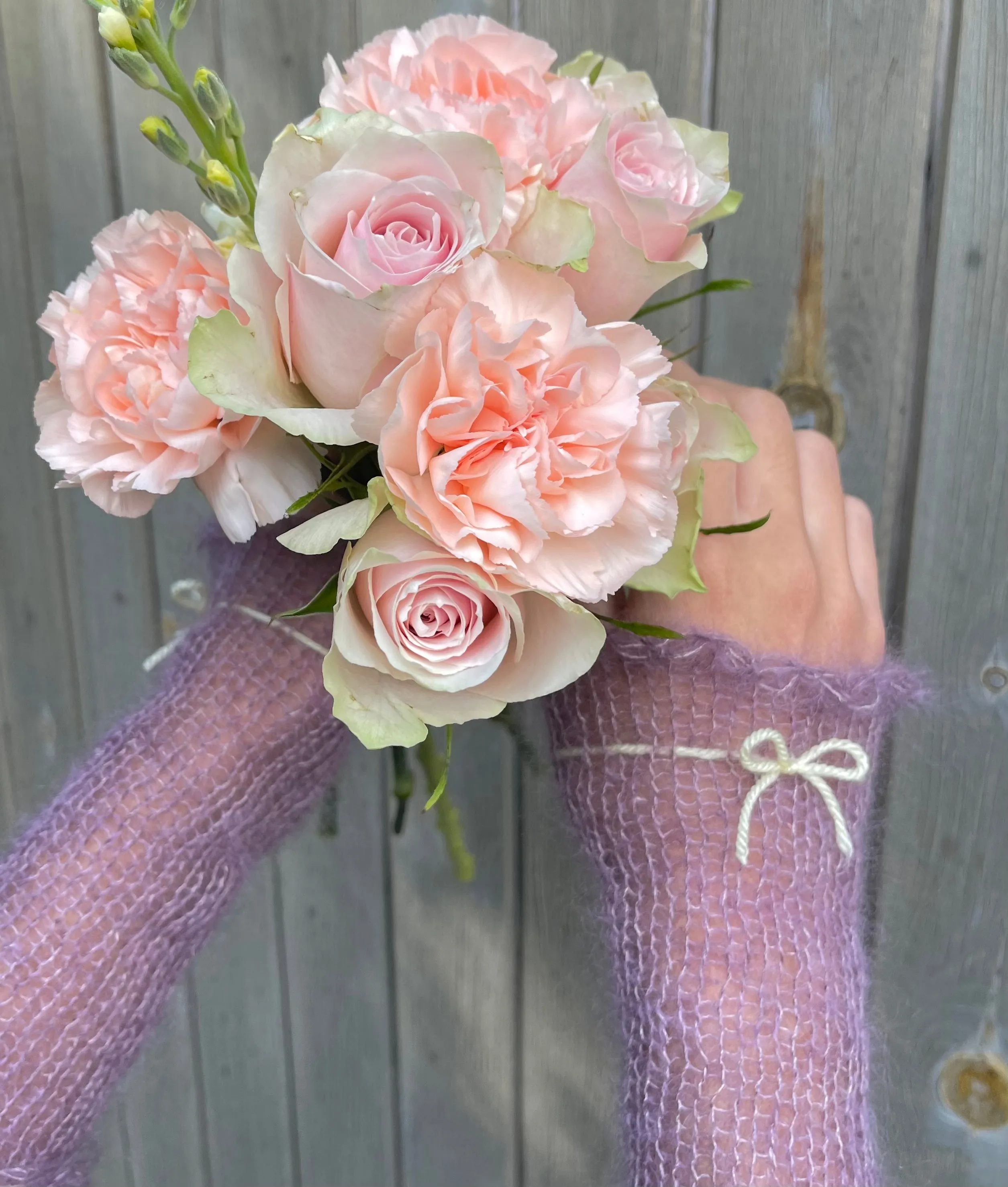 Handmade knitted mohair hand warmers in dusky purple with pastel yellow bow