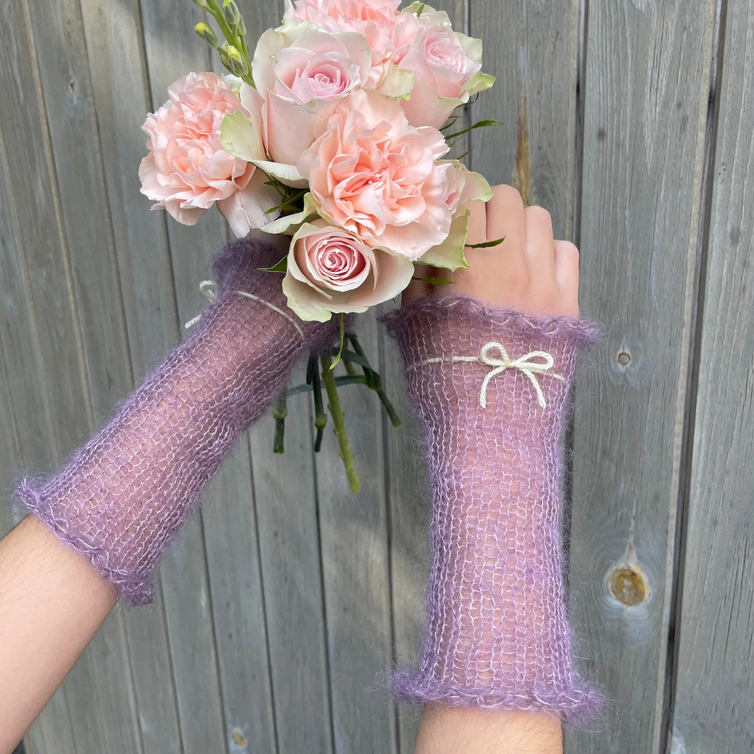 Handmade knitted mohair hand warmers in dusky purple with pastel yellow bow