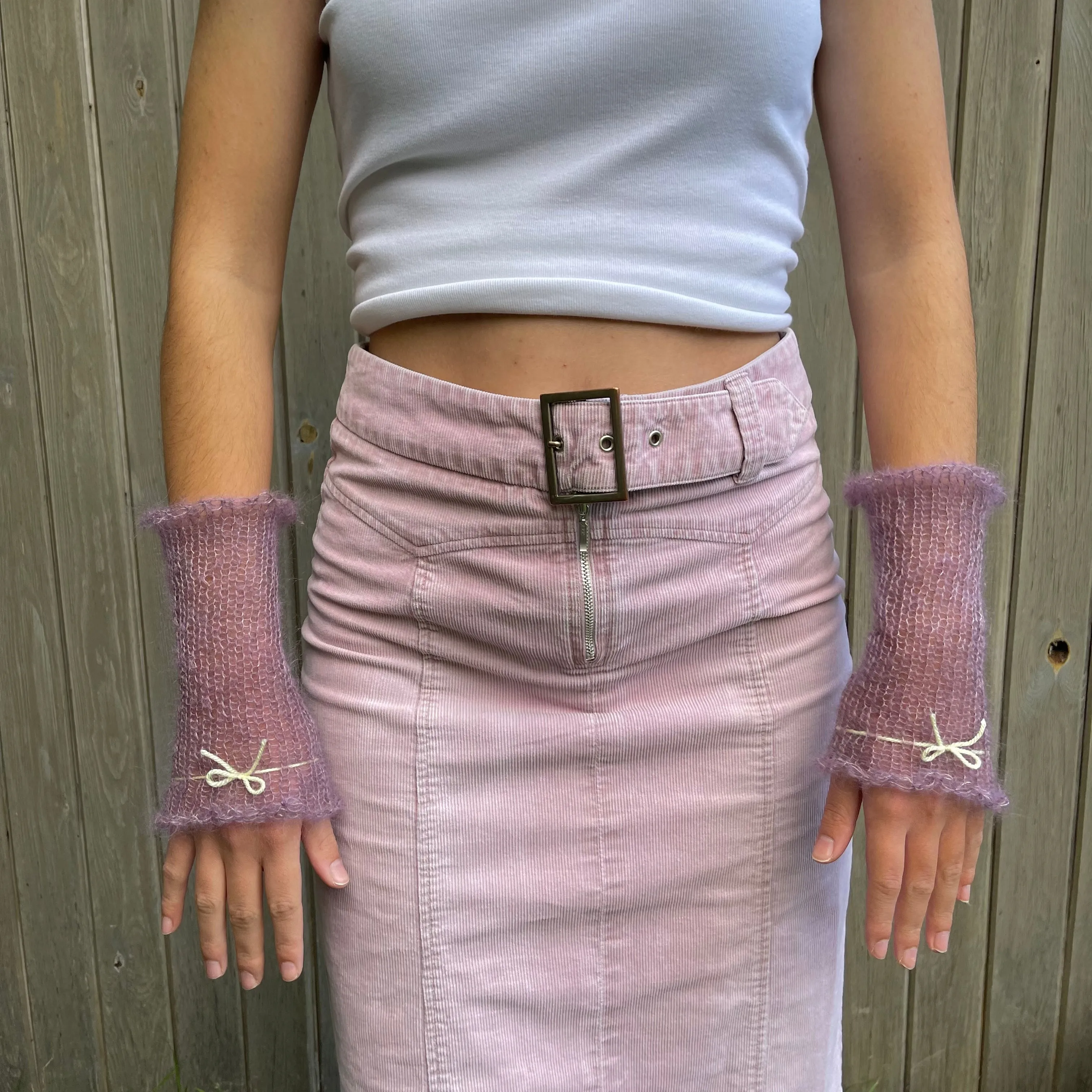 Handmade knitted mohair hand warmers in dusky purple with pastel yellow bow